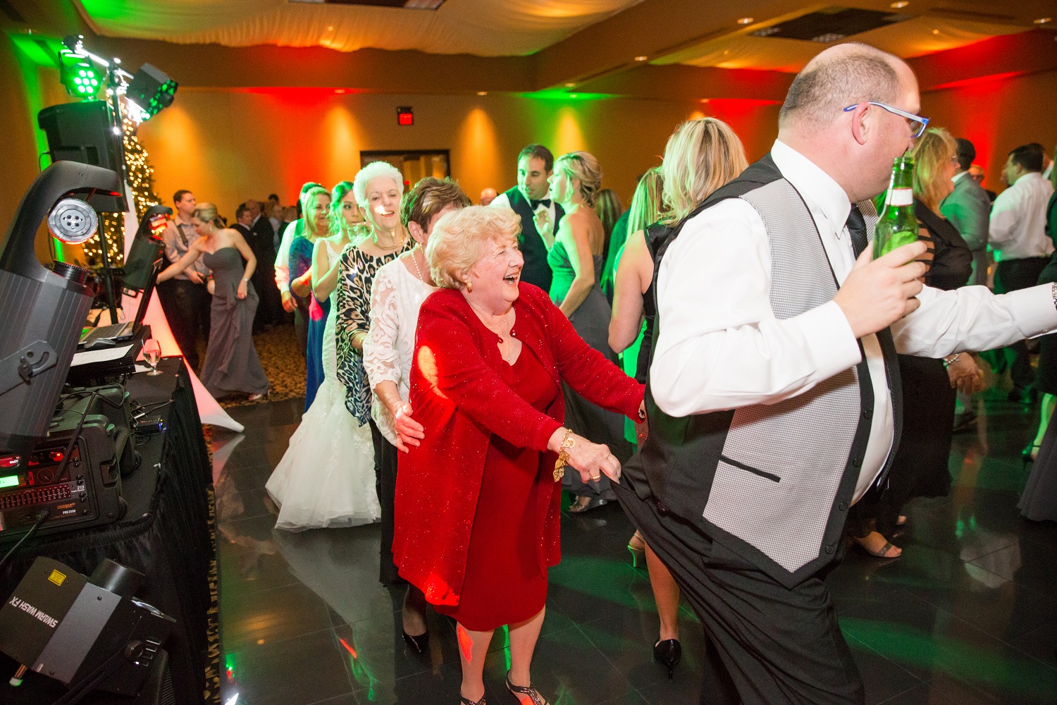 Packed wedding dance floor with All-Stars Events DJ and uplighting